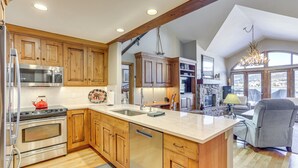A spacious kitchen with wooden cabinets, stainless steel appliances, and a large island. - Seasons Lodge at Arrowhead: Beaver Creek Condo! (Edwards)