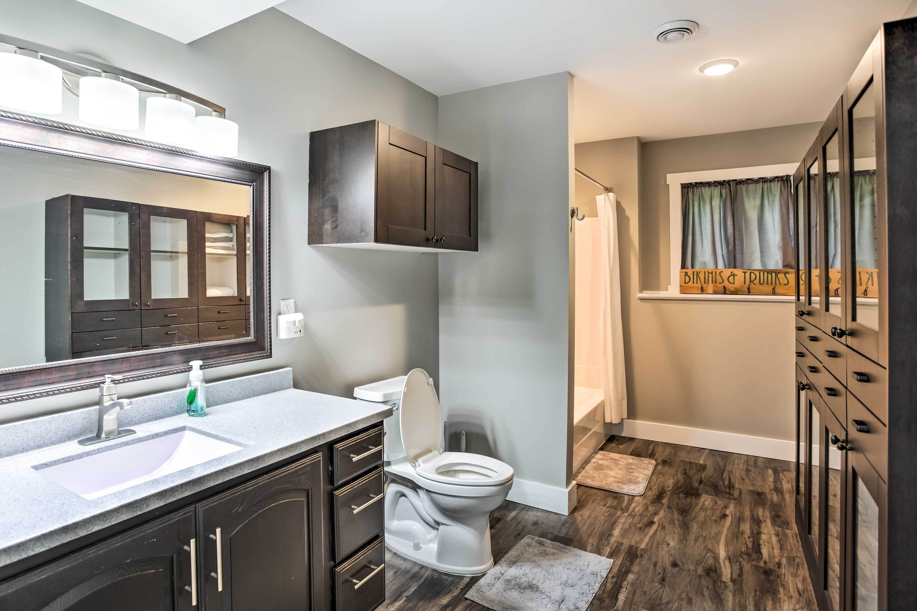 A modern bathroom with a vanity, toilet, and shower area.