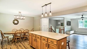 Una cocina amplia con armarios de madera, una isla grande e iluminación colgante.