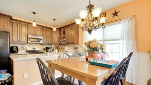 A kitchen with wooden cabinets, a central island, and a chandelier. - Breezy Wildwood Condo ~ 2 Blocks to Beach! (Wildwood)