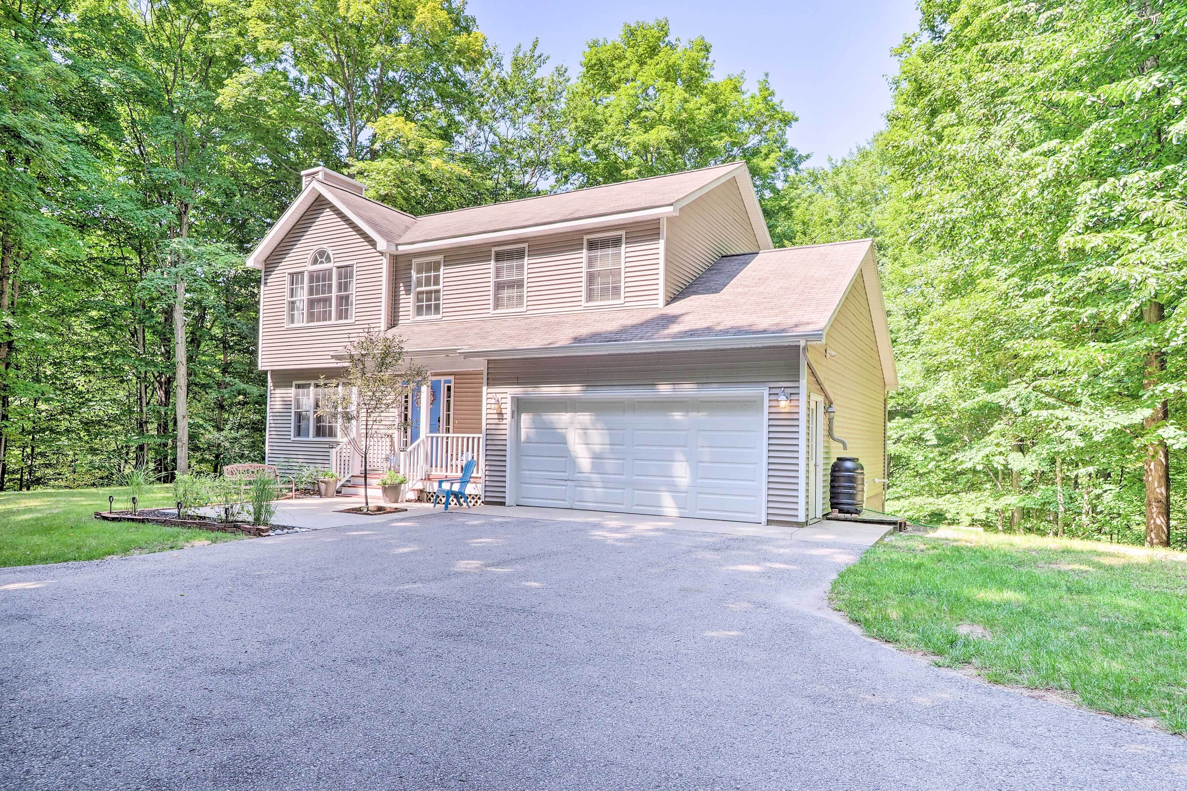 A two-story house with a garage, surrounded by a well-maintained lawn and trees.