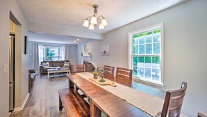 A spacious dining area with a long wooden table, surrounded by chairs, and a chandelier above. - Beulah Family Home ~ 2 Mi to Dtwn + Beach! (Beulah)
