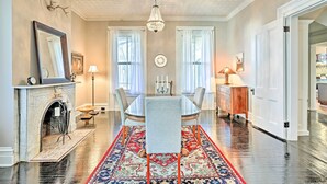 A dining room with a chandelier, a fireplace, and a large rug. - Centrally Located Apt in Victorian Mansion! (Poughkeepsie)