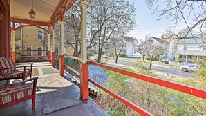 A covered porch with red railings, a bench, and a hanging light fixture. - Centrally Located Apt in Victorian Mansion! (Poughkeepsie)