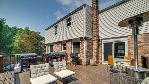 Una terraza con mobiliario exterior, una parrilla y una mesa de patio.