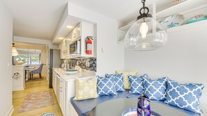 A modern kitchen with white cabinets, a built-in microwave, and a fire extinguisher.
