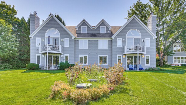 A large, two-story house with a symmetrical facade, multiple windows, and a well-maintained lawn.