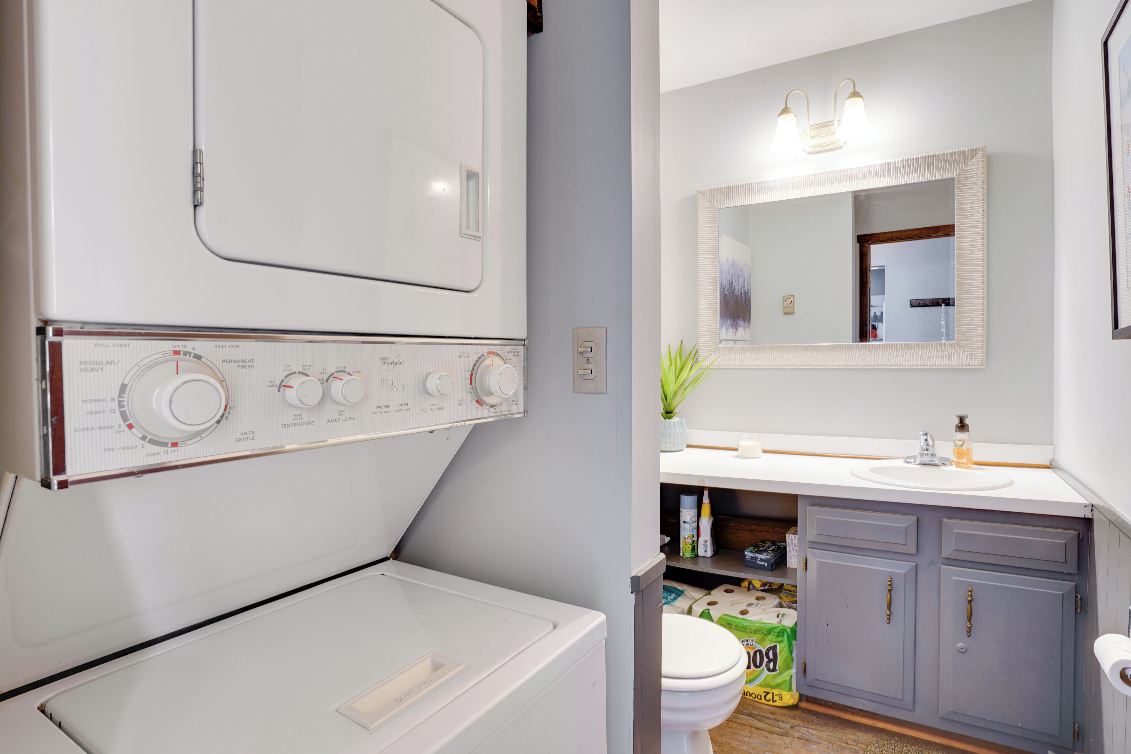 A modern bathroom with a built-in washer and dryer, a sink, and a toilet.