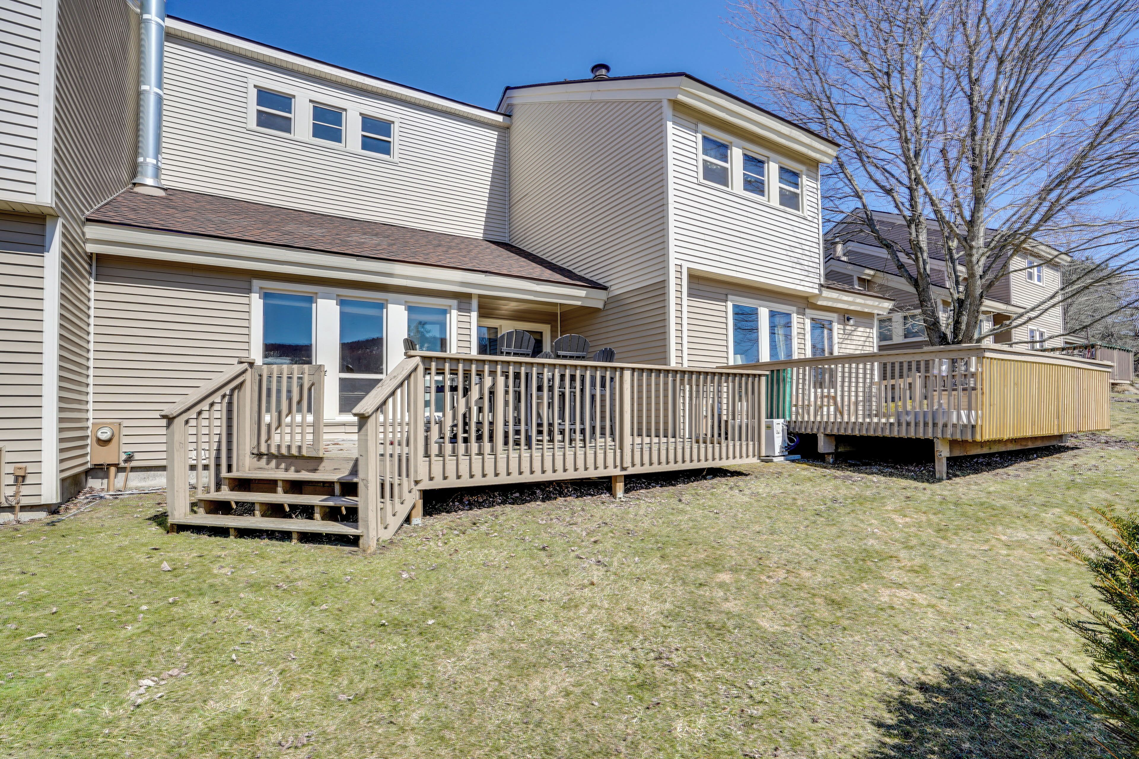 A two-story residential building with a deck and a small outdoor area.