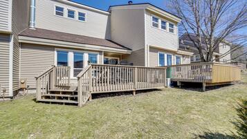 A two-story residential building with a deck and a small outdoor area.