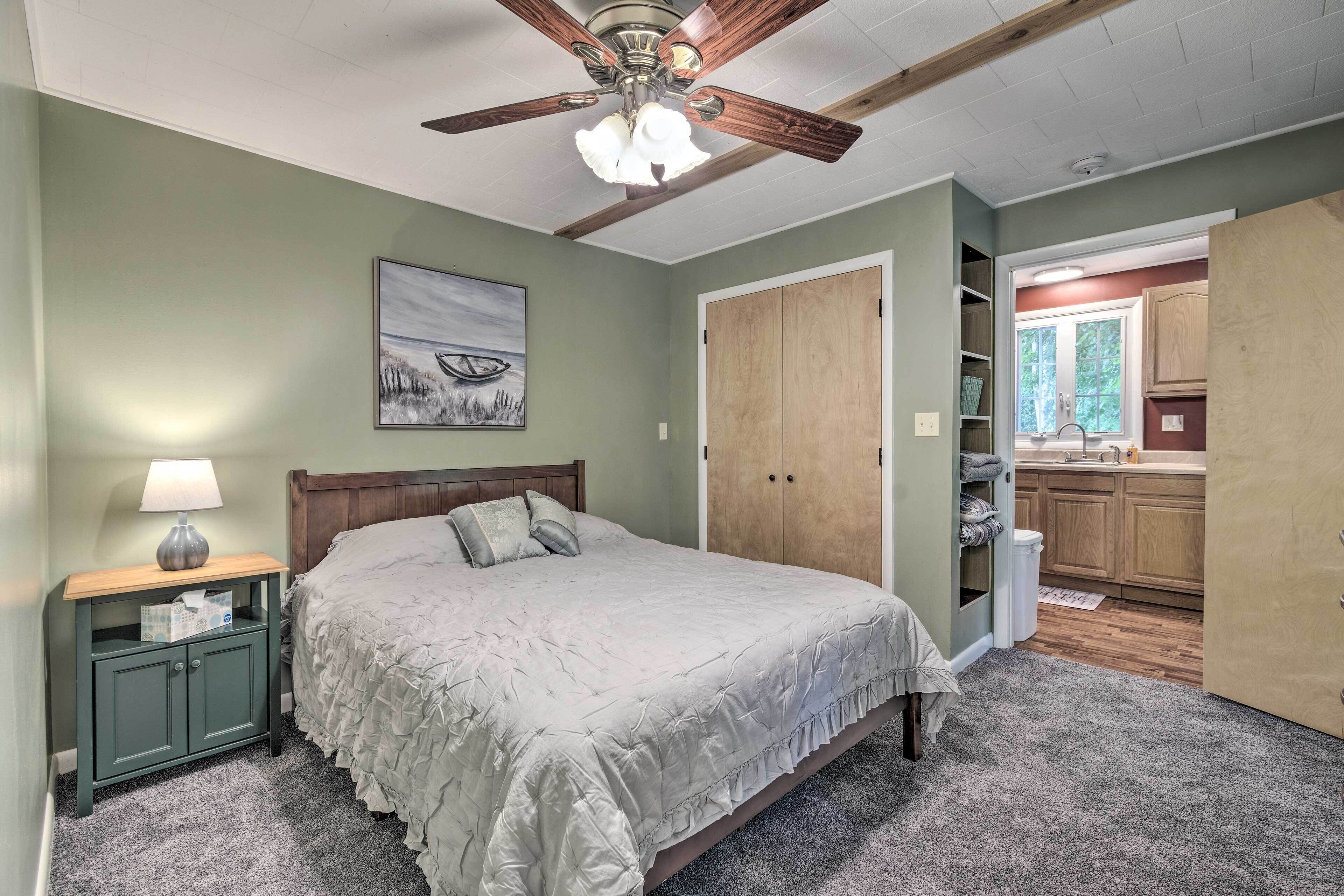 A bedroom with a bed, nightstand, and a ceiling fan.