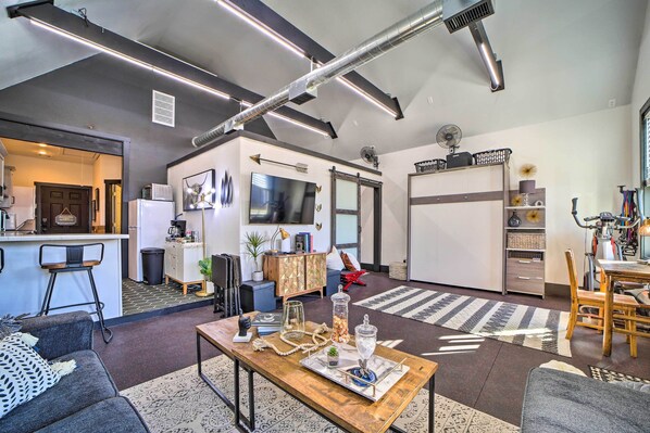 A modern living room with a wooden coffee table, a sofa, and a dining area with chairs.