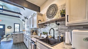 A modern kitchen with a large island, stainless steel appliances, and a unique backsplash. - Cozy Carlton Landing Home - Near Lake Eufaula (Eufaula)
