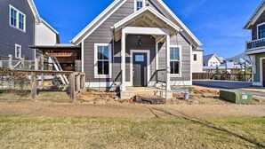 A two-story house with a front porch, a visible garage, and a fenced yard. - Cozy Carlton Landing Home - Near Lake Eufaula (Eufaula)
