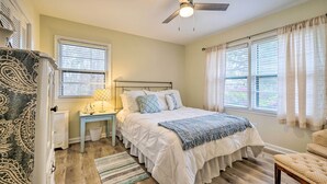 A bedroom with a bed, nightstand, lamp, and a ceiling fan. - Cozy Wilmington Vacation Rental: 10 Mi to Beach! (Wilmington)