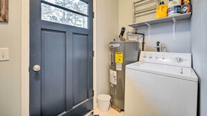 A laundry room with a washing machine, a dryer, and shelves with cleaning supplies. - Cozy Wilmington Vacation Rental: 10 Mi to Beach! (Wilmington)
