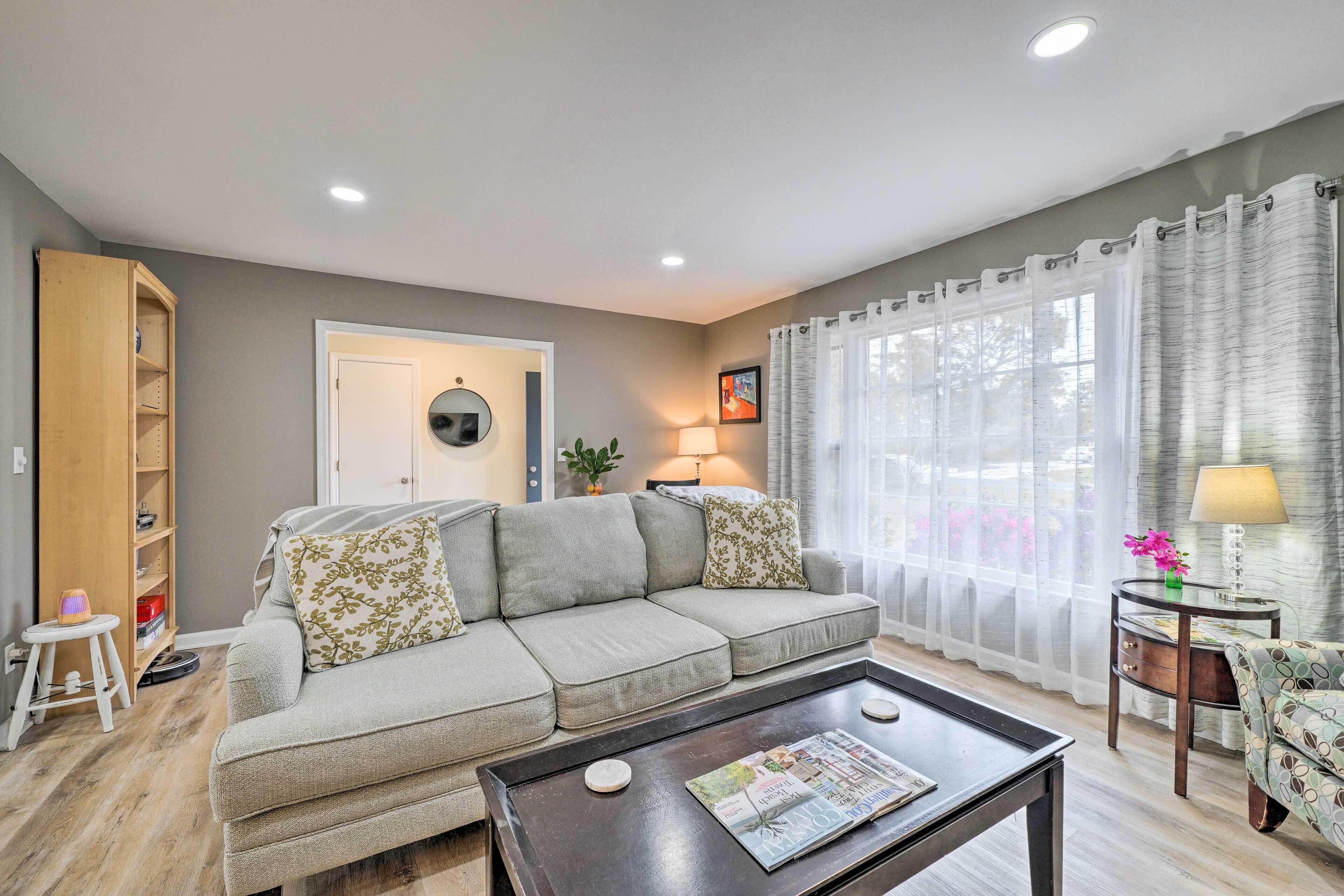 A living room with a sofa, coffee table, and a bookshelf.