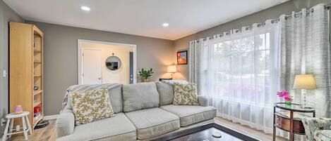 A living room with a sofa, coffee table, and a bookshelf.