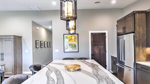 A kitchen with a marble island, stainless steel appliances, and a pendant light. - Chic Plymouth Townhome < 1 Mi to Road America (Plymouth)
