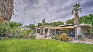 A modern house with a covered patio, a well-maintained lawn, and a variety of plants. - Near Golfing: Palm Desert Oasis w/ Pool & Spa (Palm Desert)