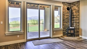 A modern interior with a stone accent wall, a fireplace, and a view through large sliding glass doors.