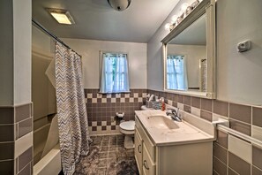 Une salle de bain équipée d’une douche, de toilettes, d’un lavabo et d’un miroir.