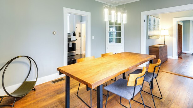 A dining area with a wooden table and chairs, a hanging light fixture, and a view into the kitchen. - Chester Home ~ 12 Mi to Magic Mountain Ski Area (Chester)