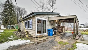 A single-story house with a covered porch, a garage, and a small yard with snow patches.