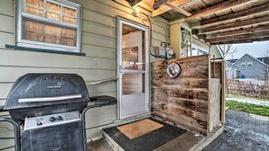 A Char-Bri grill with a control panel, a wooden door with a clock, and a window with blinds.