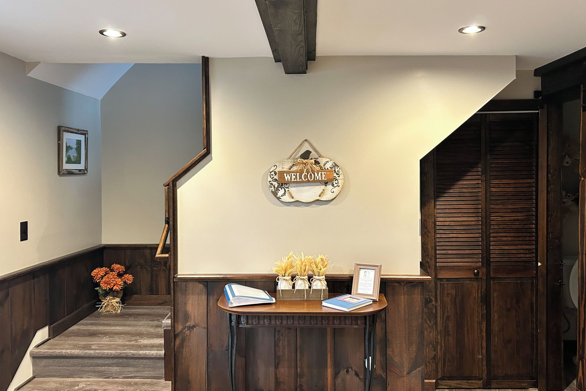 A reception area with a wooden desk, a welcome sign, and a framed picture on the wall.