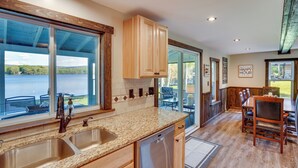 Una cucina con un'ampia finestra, mobili in legno e lavastoviglie.