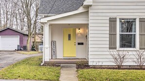 A single-story house with a yellow front door, a garage, and a small porch area. - Charming Greencastle Home < 1 Mi to Depauw! (Greencastle)