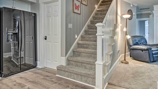 A modern kitchen with a built-in refrigerator and a staircase leading to another level. - Charming Greencastle Home < 1 Mi to Depauw! (Greencastle)