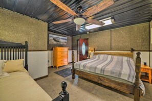 A bedroom with a wooden bed, a ceiling fan, a dresser, and a radiator. - Family Leatherwood Resort Cabin w/ Fire Pit! (Dover)