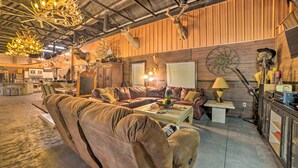 A rustic interior with leather sofas, a wooden ceiling, and mounted animal heads. - Family Leatherwood Resort Cabin w/ Fire Pit! (Dover)