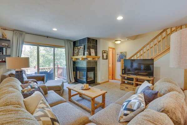 A cozy living room with a fireplace, a television, and comfortable seating. - Downtown Winter Park Townhouse 3 Mi to Ski Resort! (Winter Park)