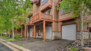 A multi-story residential building with a wooden exterior, stone accents, and a balcony. - Downtown Winter Park Townhouse 3 Mi to Ski Resort! (Winter Park)