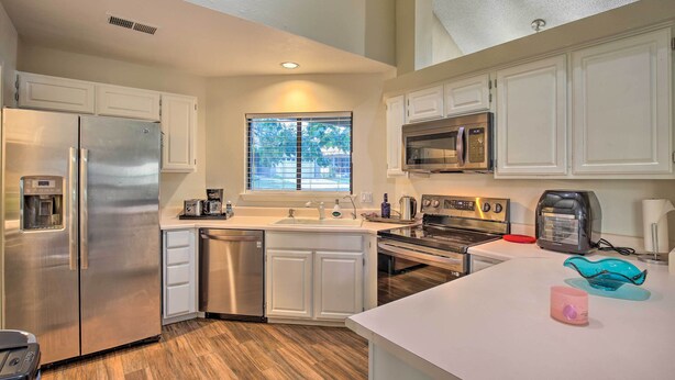 A modern kitchen with white cabinets, stainless steel appliances, a window with blinds, and a countertop with a toaster and a kettle. - Family Retreat ~ 1 Mi to Hill Country Mile! (Boerne)