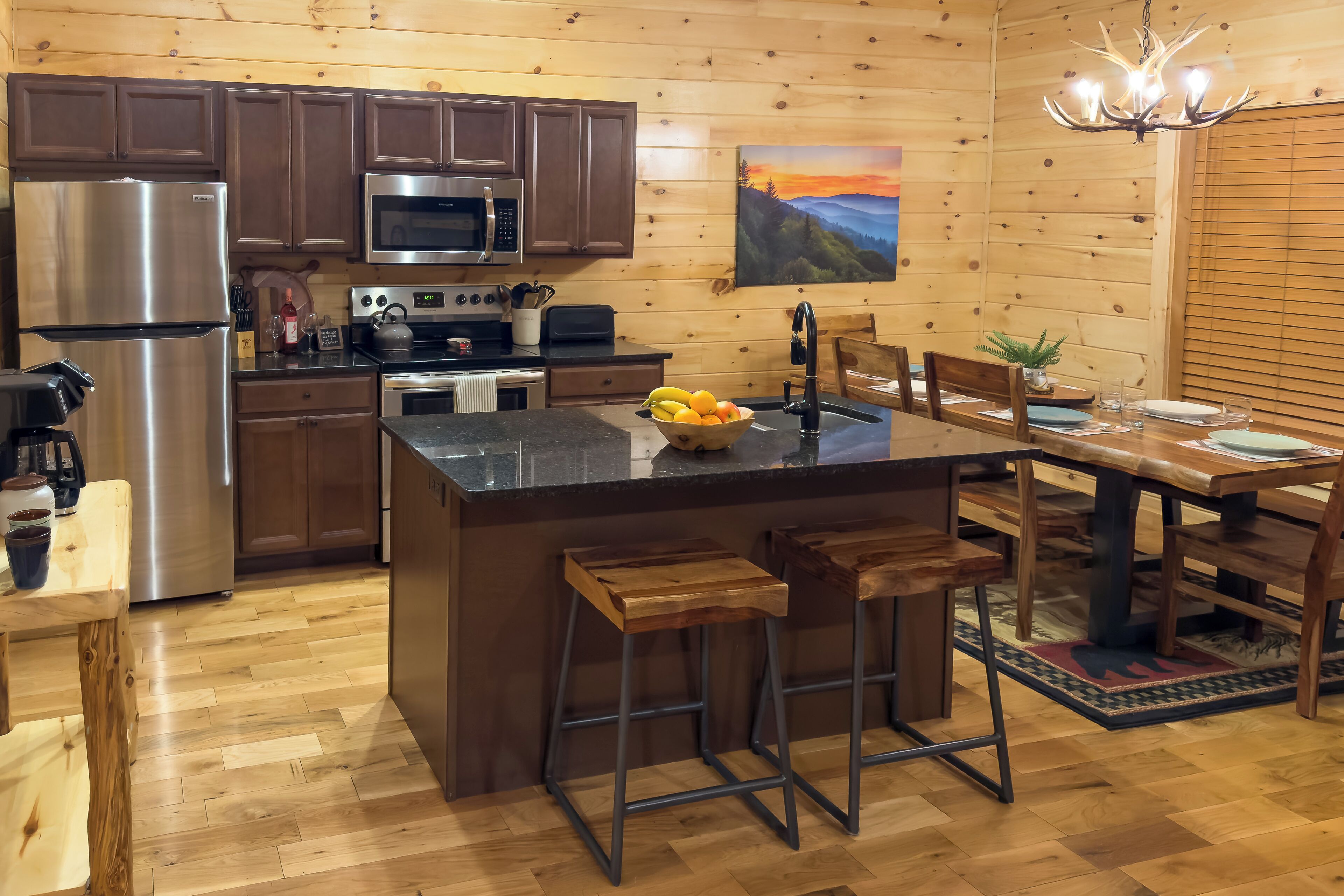 A modern kitchen with wooden cabinets, stainless steel appliances, and a central island with stools.