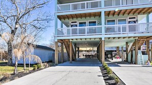 A two-story building with a covered patio area, wooden beams, and a view of a backyard. - La Porte Getaway w/ Deck: Steps to Beach! (La Porte)
