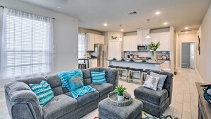 A modern living room with grey sofas, a coffee table, and a kitchen in the background. - La Porte Getaway w/ Deck: Steps to Beach! (La Porte)