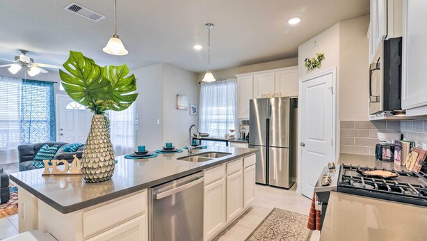 A modern kitchen with stainless steel appliances, a central island, and pendant lighting. - La Porte Getaway w/ Deck: Steps to Beach! (La Porte)
