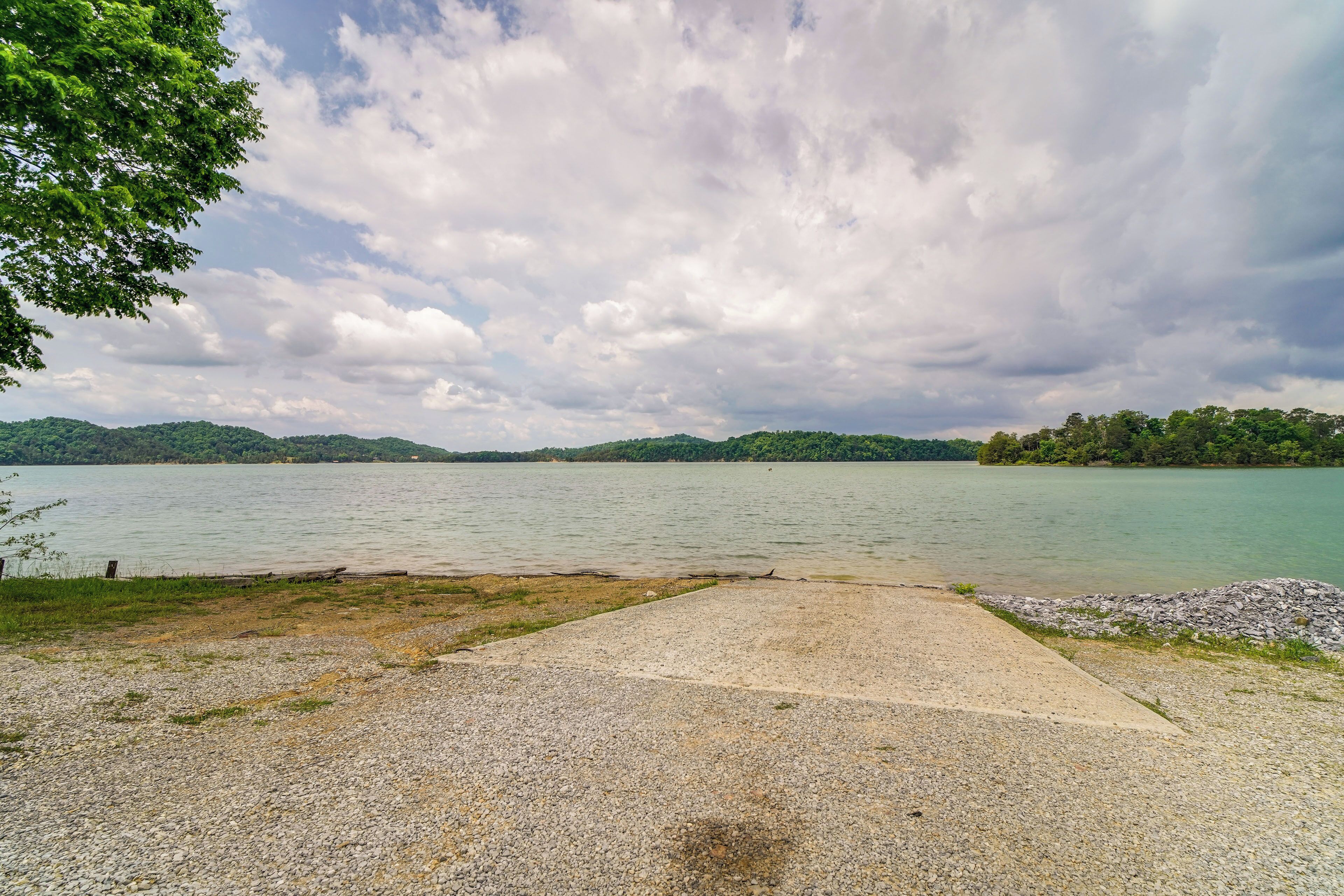 Un sentier de gravier mène à un lac, d’où l’on a une vue dégagée sur l’eau et sur les collines lointaines.