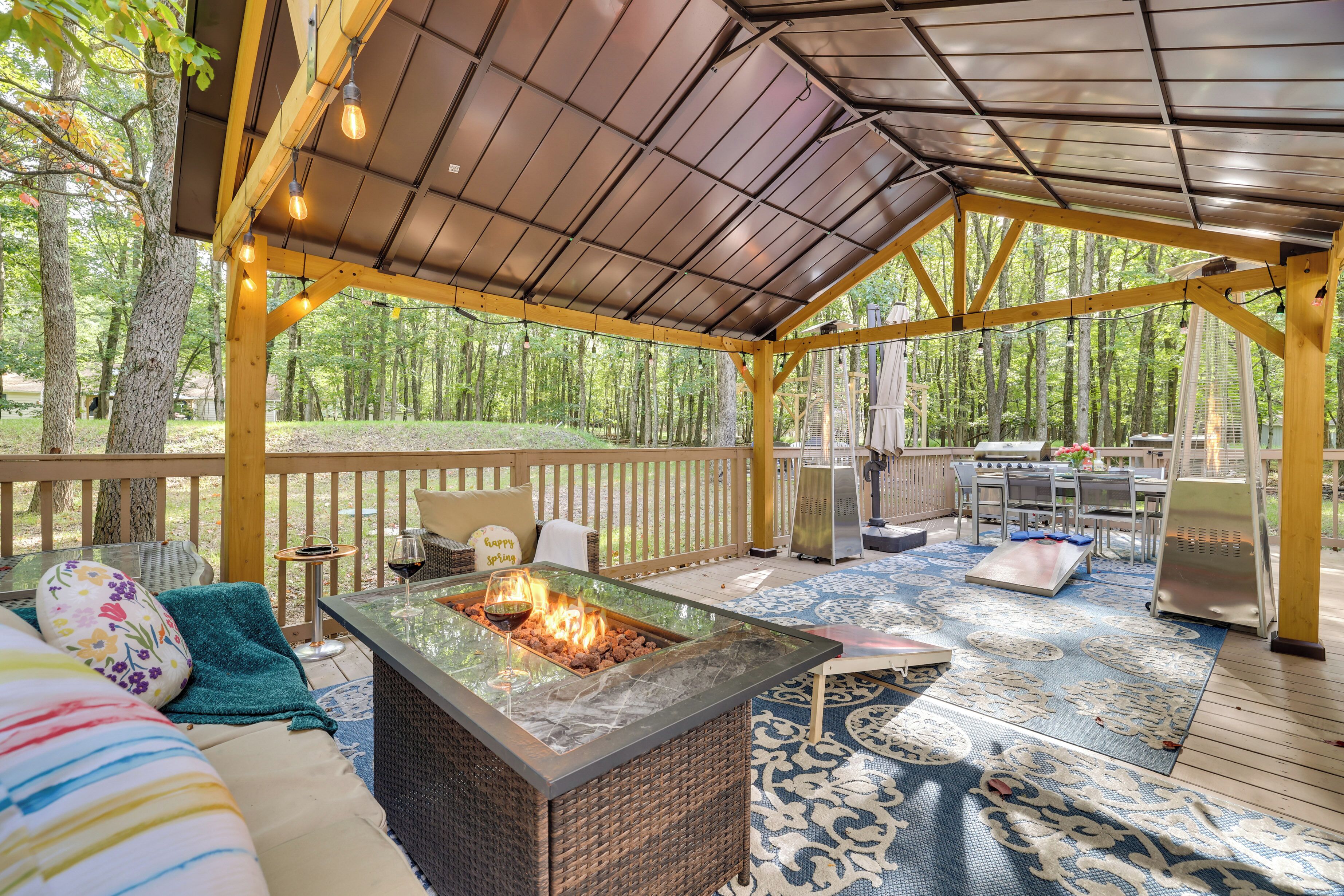 Un patio techado al aire libre con una chimenea, asientos y una zona de parrillada.