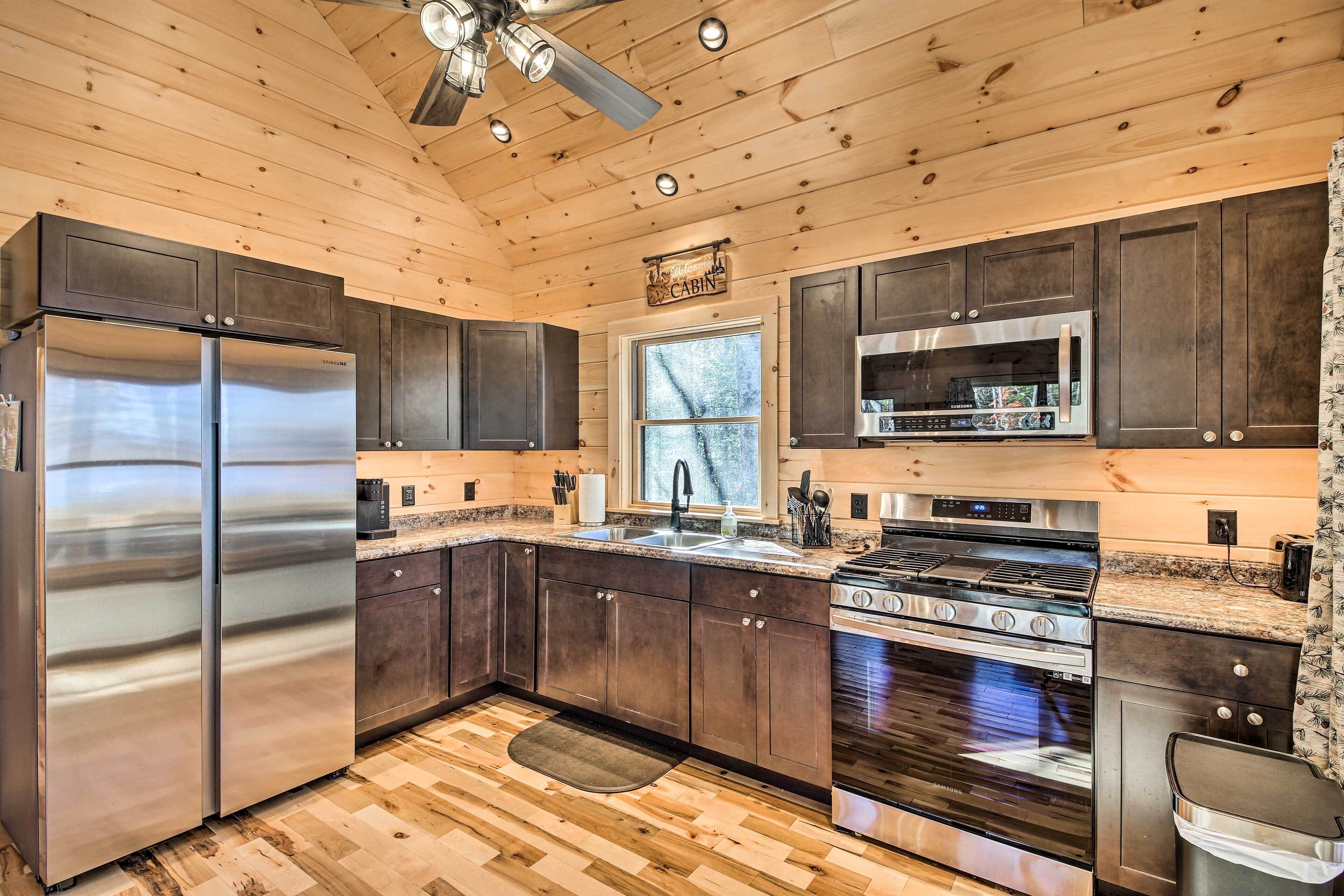 Una cocina moderna con electrodomésticos de acero inoxidable, muebles de madera y un patrón de suelo tipo espiga.