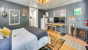 Une chambre à coucher avec un lit, un bureau, une cheminée et un téléviseur.