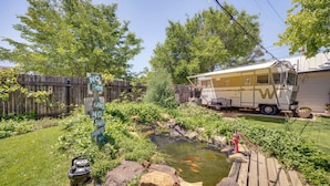 A backyard with a pond, a wooden fence, and a recreational vehicle. - Las Animas Studio w/ Lush Backyard Paradise! (Las Animas)