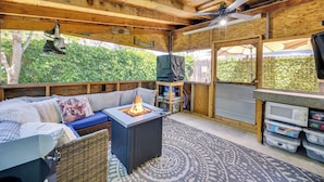 A wooden deck with a fire pit, seating area, and a television. - Las Animas Studio w/ Lush Backyard Paradise! (Las Animas)