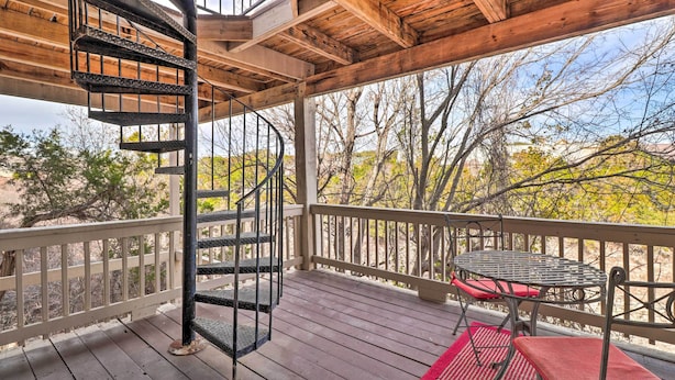 A wooden deck with a spiral staircase, a table with chairs, and a red rug. - Lakefront Home w/ Point Venture Golf Access! (Leander)