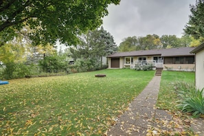 A house with a front yard, a pathway leading to the entrance, and a small garden area. - Hugo Home, Direct Lake Access & Private Dock! (Hugo)